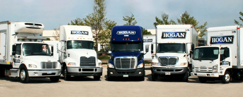 A variety of types of Hogan trucks in a row.