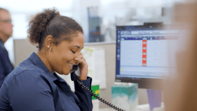 A woman at Hogan corporate wearing a headset and talking on the phone.