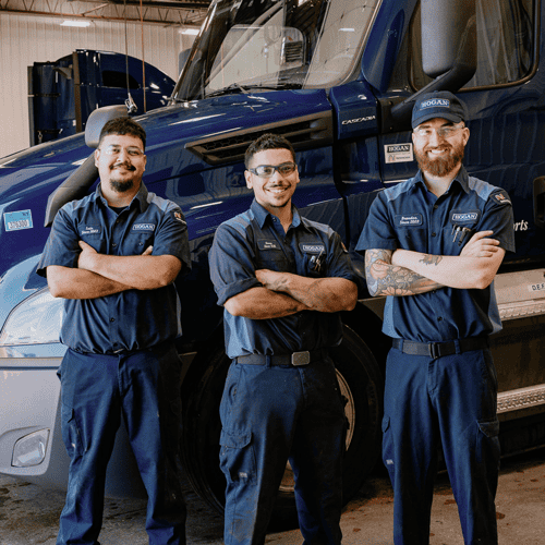 Three technicians in front of a Hogan truck.