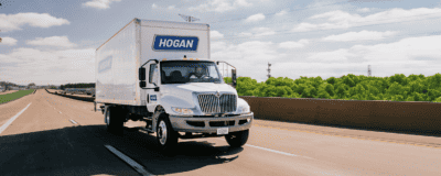 A Hogan truck on the highway in the summer.